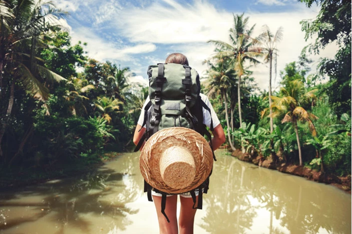 Rucksacktourist, der durch Regenwaldwasser läuft